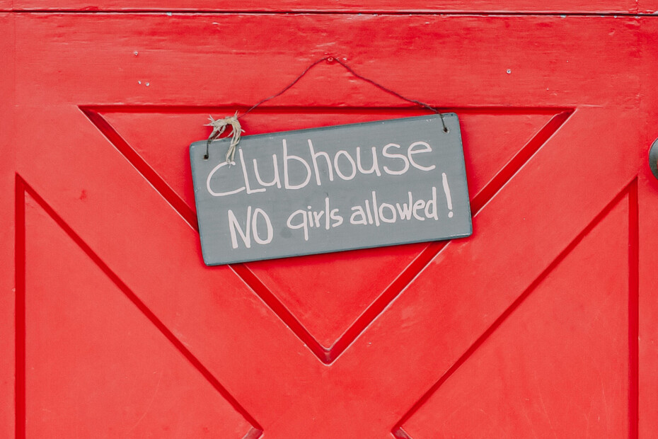 Red door with a sign nailed to it that reads: clubhouse, no girls allowed!