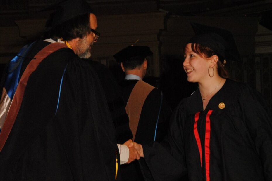 Tessa Watkins is shaking the hand of Game Art & Design department chair, Hans Westman, while crossing the stage at Soldiers & Sailors Memorial Hall at the graduation ceremony for the Art Institute of Pittsburgh.