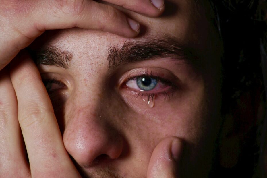 a man holding his hands to his face